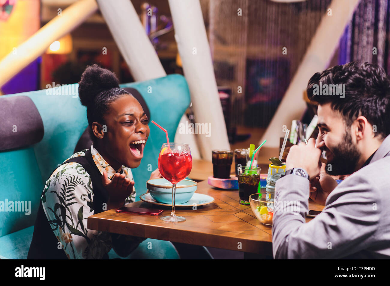 young people sitting in a cafe and talking. Young man and woman meeting ...
