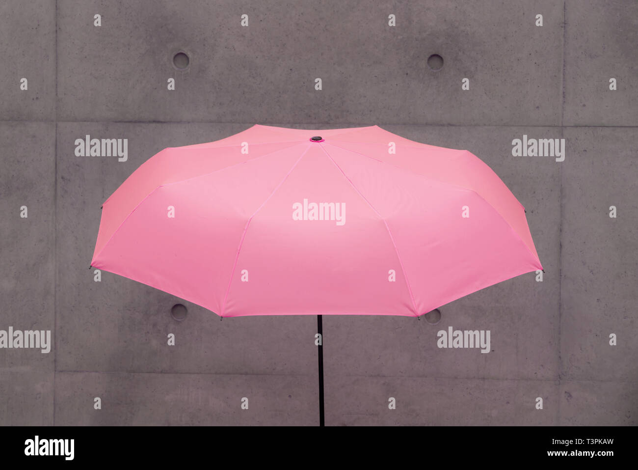 an umbrella in front of a concrete wall Stock Photo Alamy