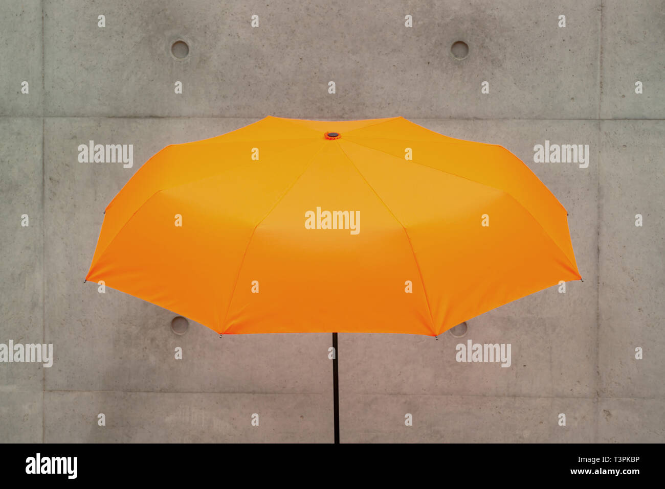 an umbrella in front of a concrete wall Stock Photo Alamy