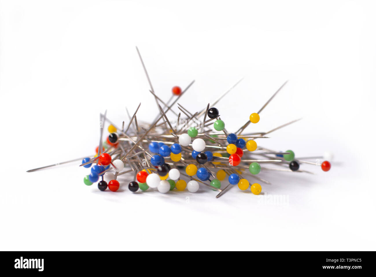 Heap of multi-coloured sewing pins on a white background, Stock image