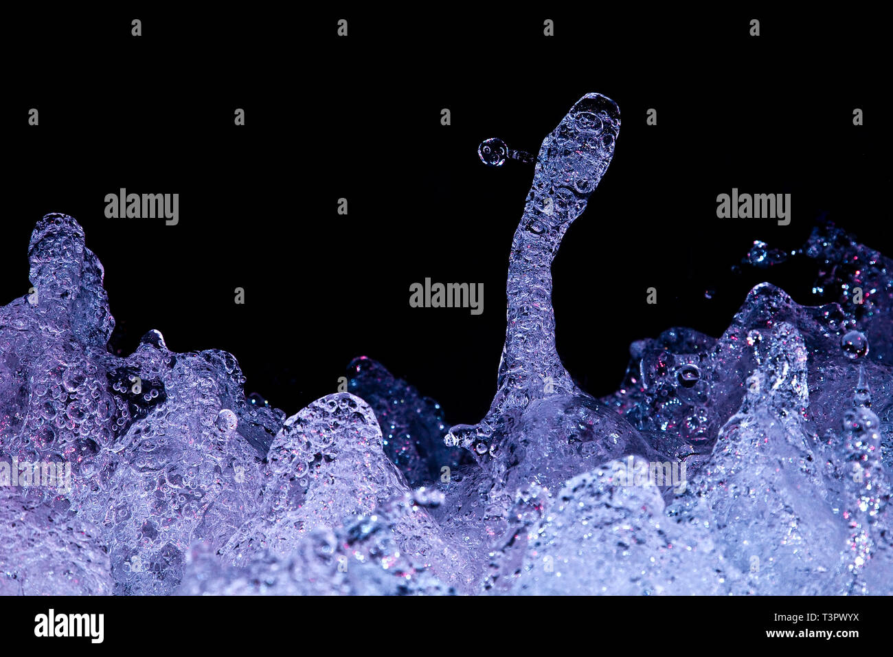 Water splashes in a little brook, taken at night and with black copy space. Stock Photo