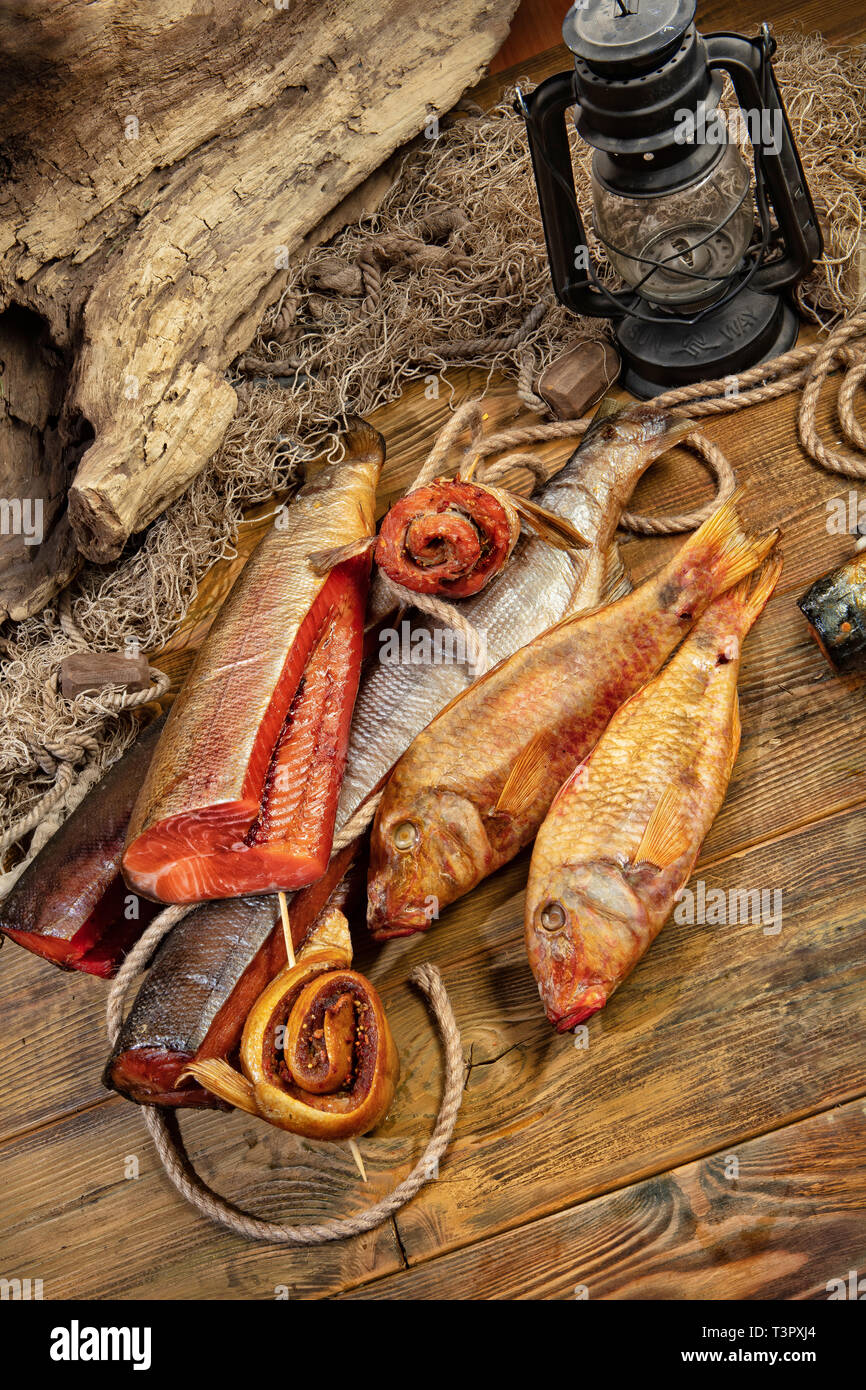 Different kinds of smoked fish and fushing net on a wooden desk Stock Photo  - Alamy