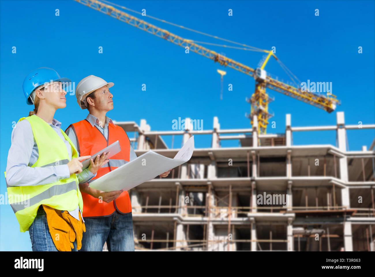 Foreman and engineer with blueprints at construction site Stock Photo