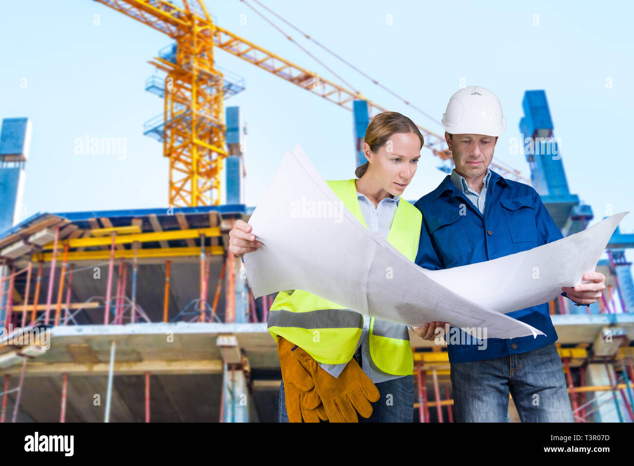 Foreman and engineer with blueprints at construction site Stock Photo