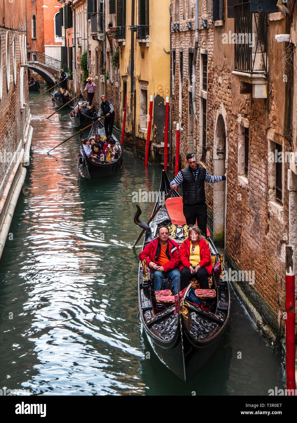 Venice Tourist Gondolas progress down a side canal Stock Photo