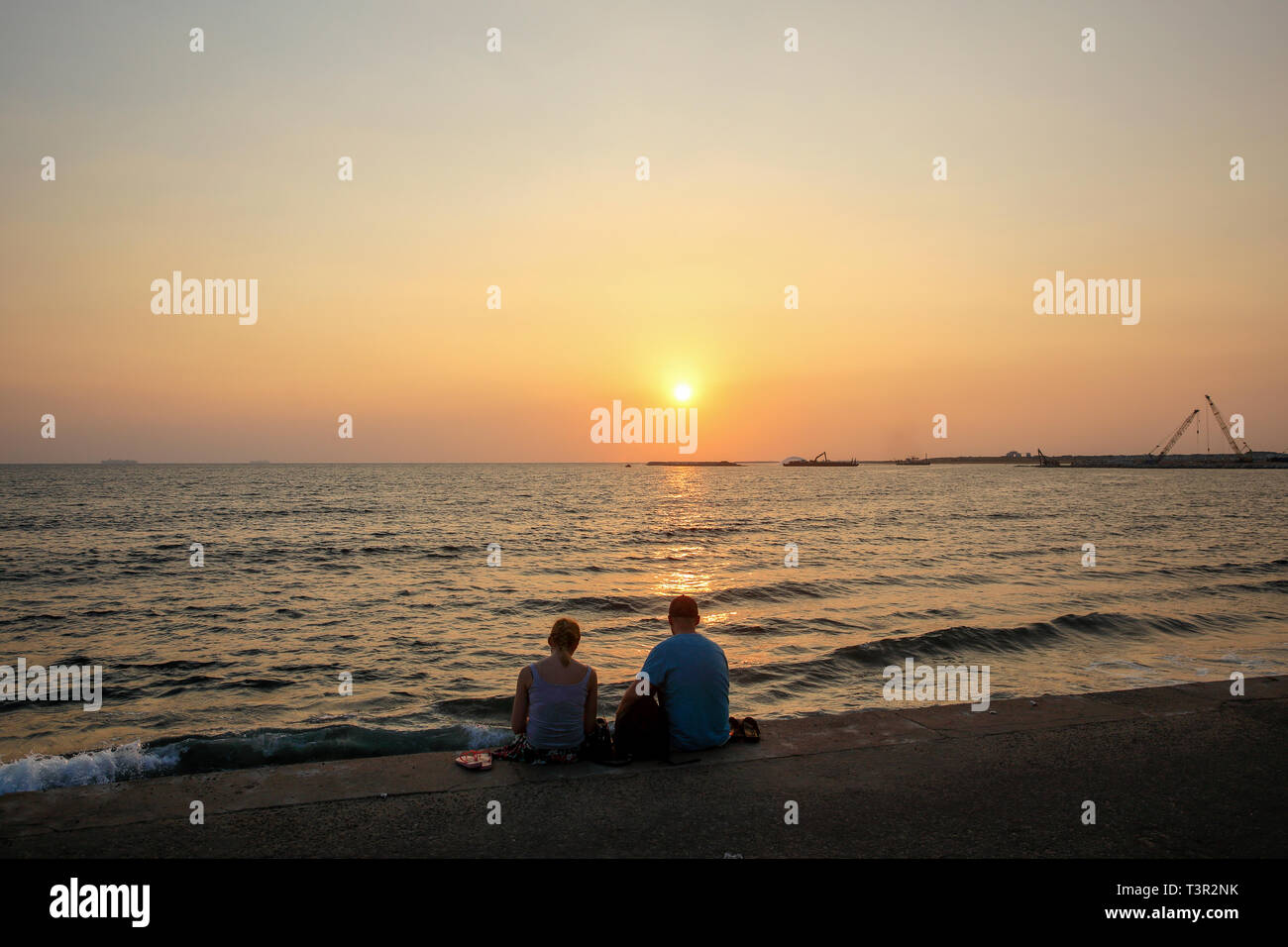 A couple watching sunset from the Galle Face Beach at Colombo, Sri Lanka. Stock Photo