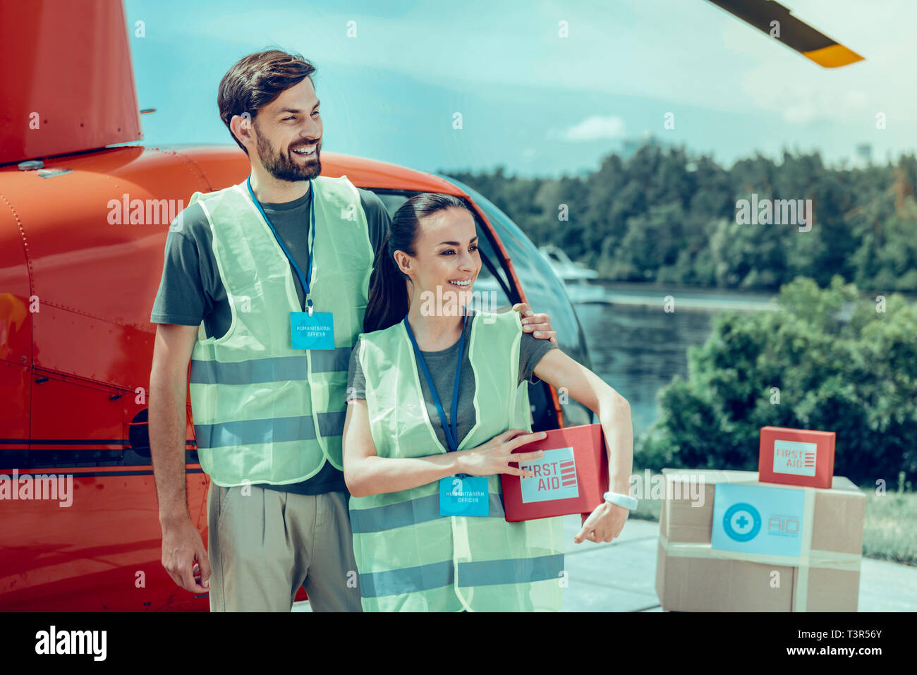 Cheerful good-looking hard-working volunteers being surrounded with boxes Stock Photo