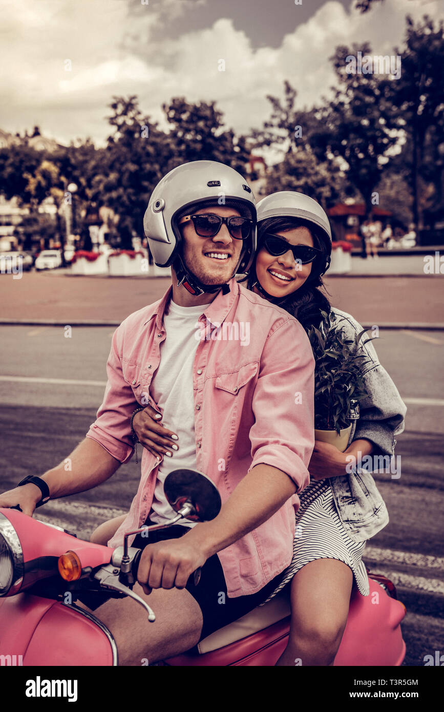 Joyful happy couple riding the motorbike together Stock Photo - Alamy