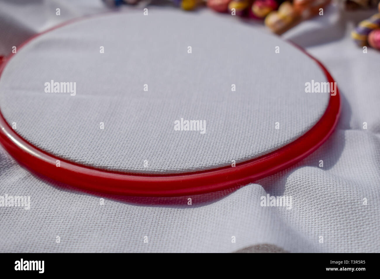 The embroidery hoop with canvas and bright sewing threads. Stock Photo