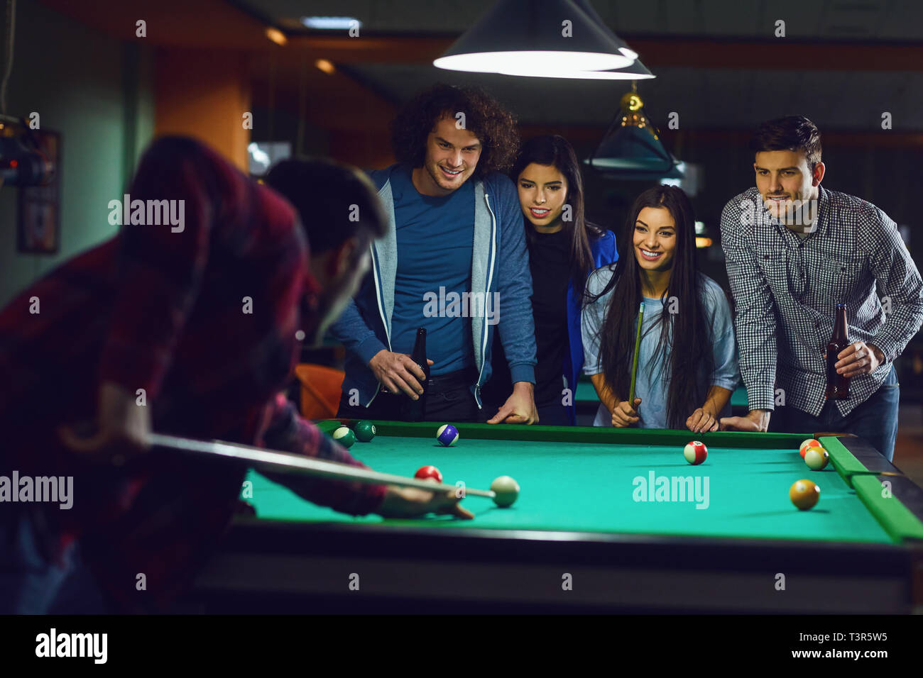 Billiards game. young friends playing pool together Stock Photo - Alamy