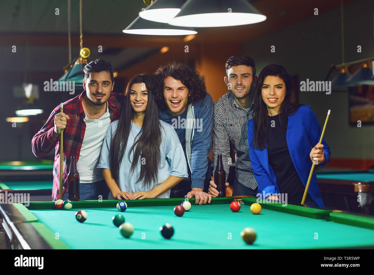 A group of young people playing fun billiards. Stock Photo