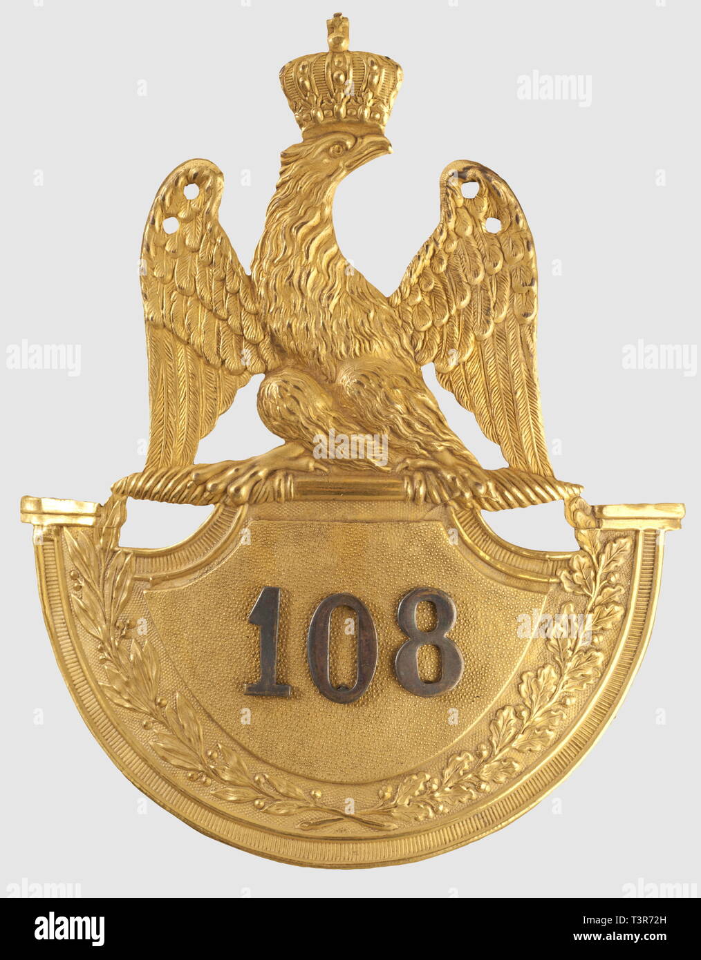 DIRECTOIRE-CONSULAT-EMPIRE 1795-1814, Plaque pour shako d'officier supérieur, du 108ème régiment d'infanterie de Ligne, modèle 1812. Plaque en cuivre jaune doré, modèle à soubassement dit de 1812, motif à l'aigle impériale couronnée surmontant un écu bordé de feuillages de laurier et de chêne, au centre, sur fond sablé, chiffre '108' rapporté en argent. Les attributs des extrémités de l'écu (grenades, cors?) ont été volontairement supprimés, ce qui pourrait indiquer un colonel ou un major commandant le régiment, toutes compagnies confondues. Très, Additional-Rights-Clearance-Info-Not-Available Stock Photo