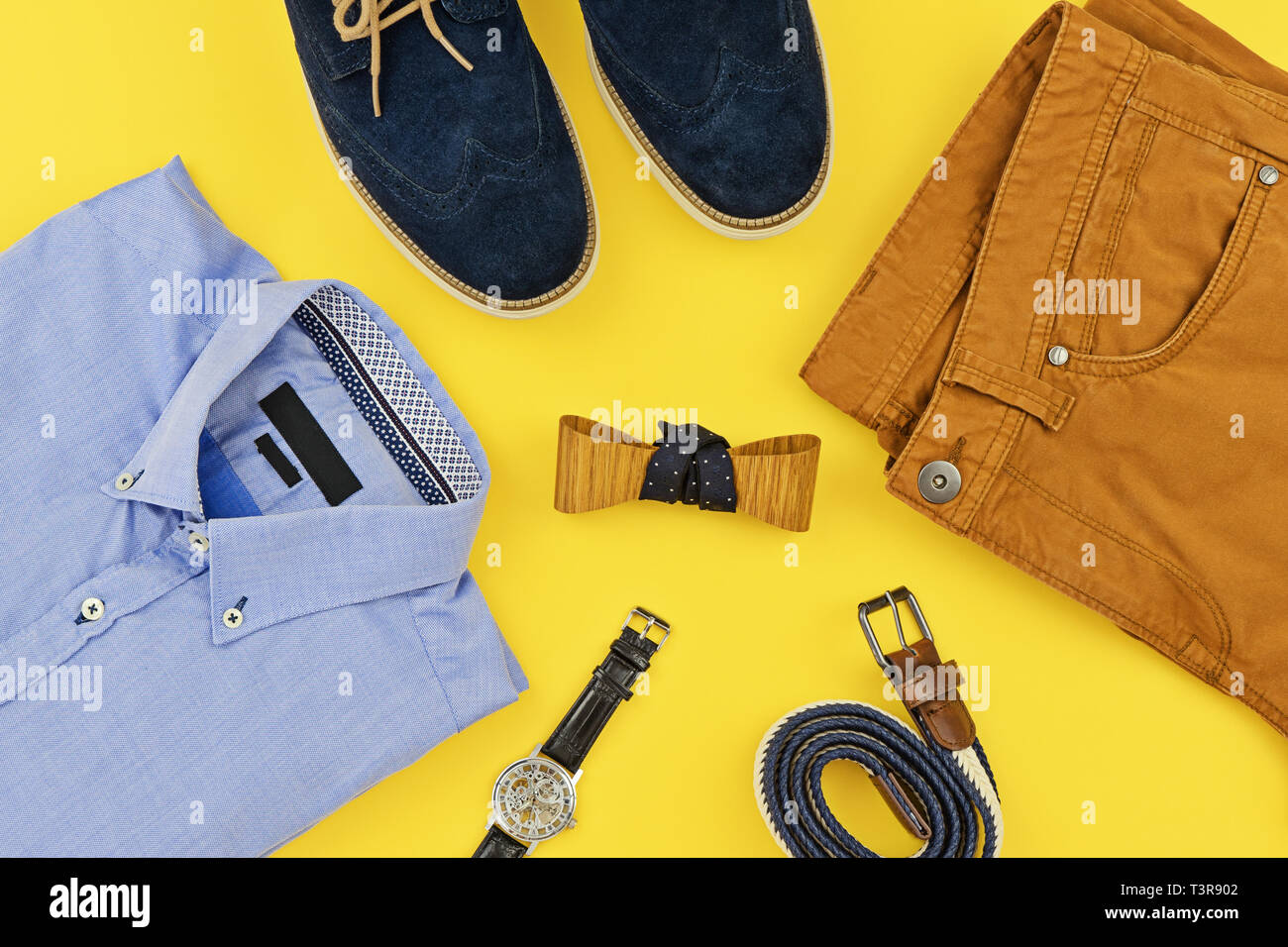 Casual outfits for man clothing with blue shirt, mustard jeans, belt,  watch, blue shoes and accessories isolated on yellow, top view Stock Photo  - Alamy
