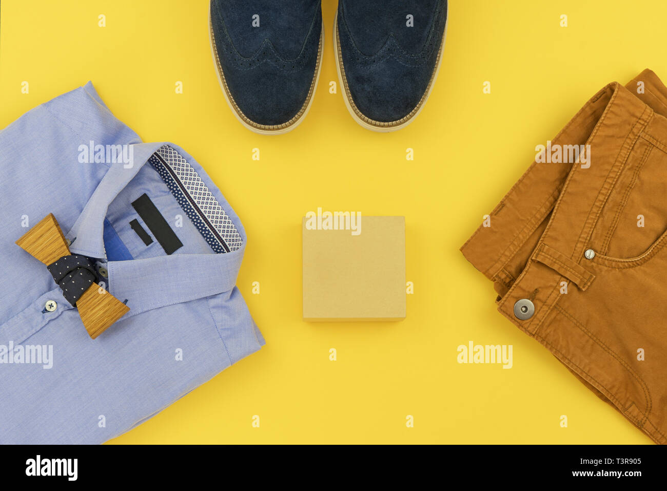 Casual outfits for man clothing with blue shirt, mustard jeans, belt,  watch, blue shoes and accessories isolated on yellow background, top view  Stock Photo - Alamy