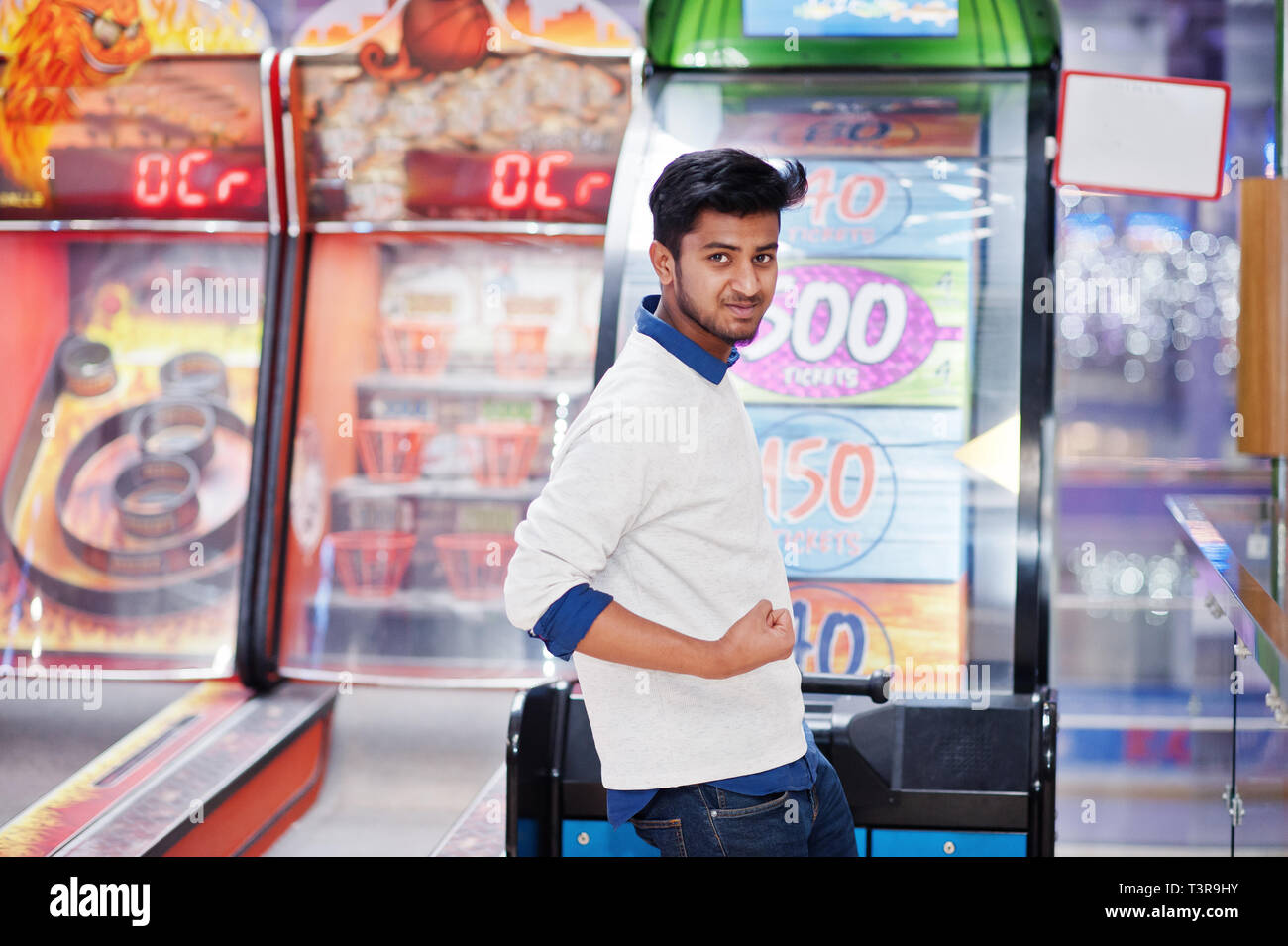 Young asian man play on fortune wheel slot machines to try win at lottery great prize. Gamble jackpot prize spin. Round drum casino money game. Stock Photo