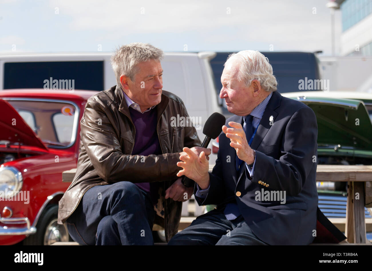 Tiff Needell interviewing mini rallying  legend Paddy Hopkirk MBE, in the International Paddock, during the Silverstone Classic Media Day 2019 Stock Photo