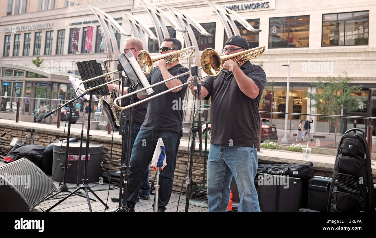 Two trumpists and a saxophonist play outdoors in the Playhouse Square Theater District in downtown Cleveland, Ohio, USA. Stock Photo