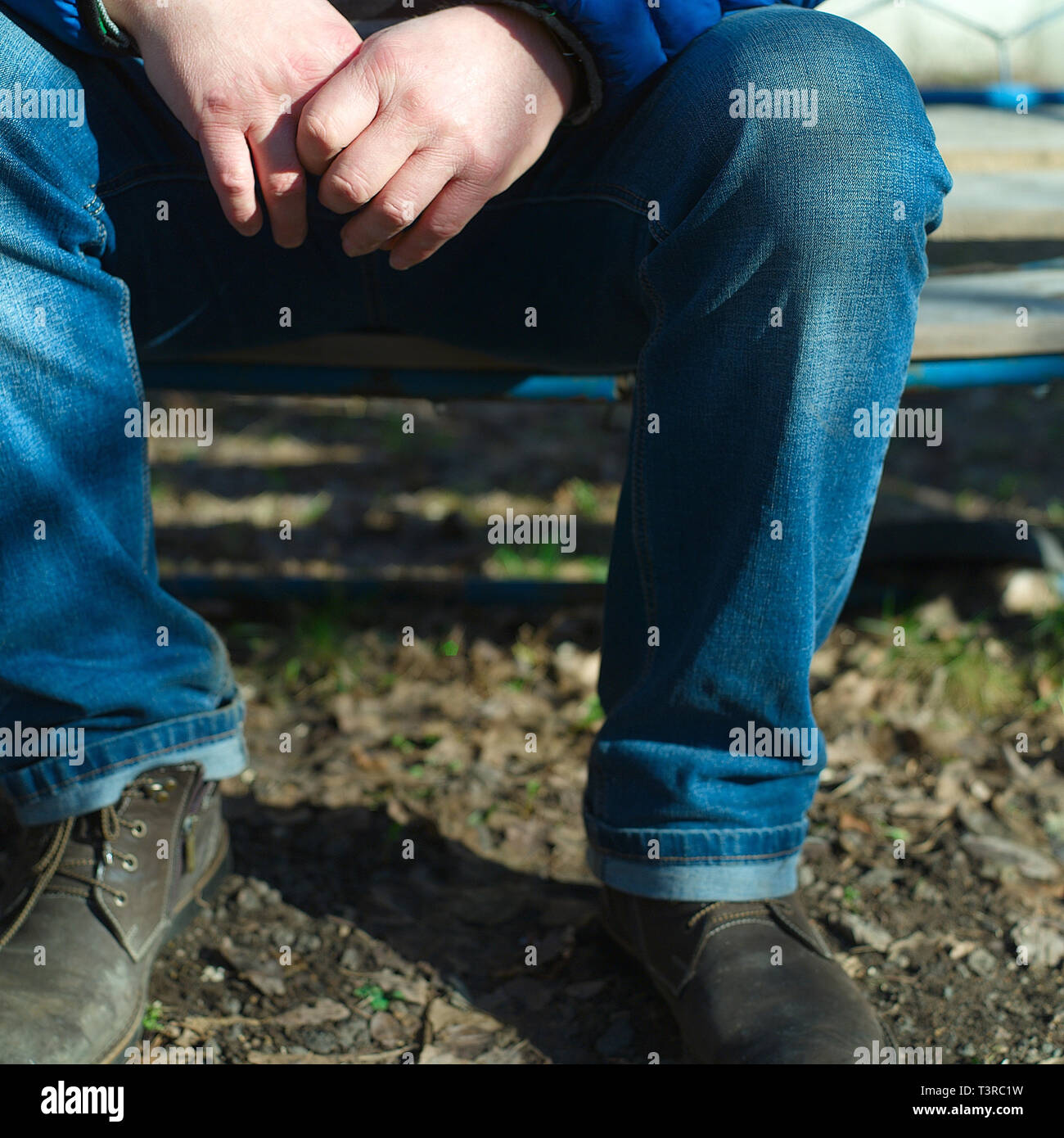 A man sitting outdoor with interlocking fingers, outdoor square shot Stock Photo Alamy