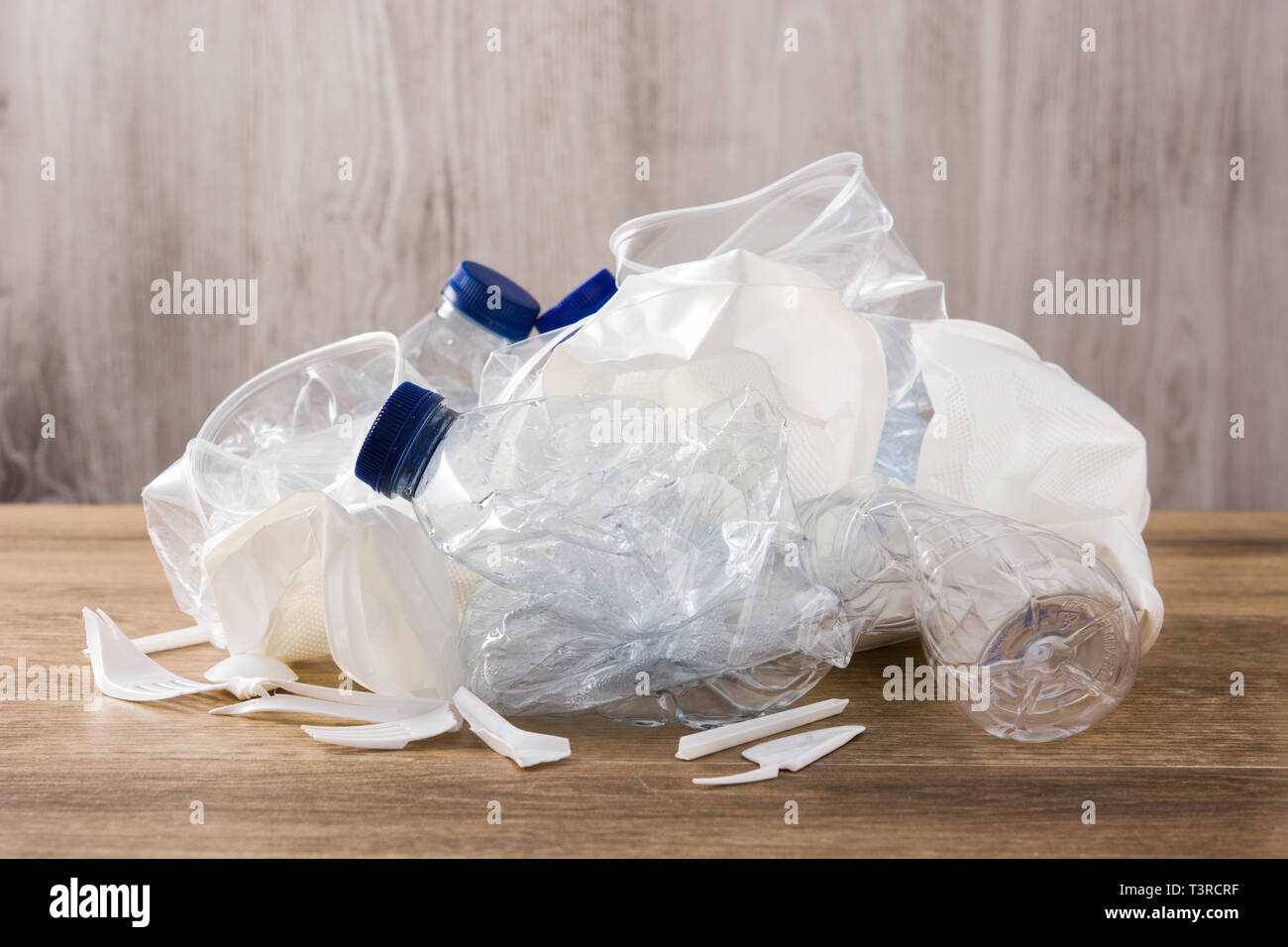 Disposable waste plastic on wooden background. Stock Photo