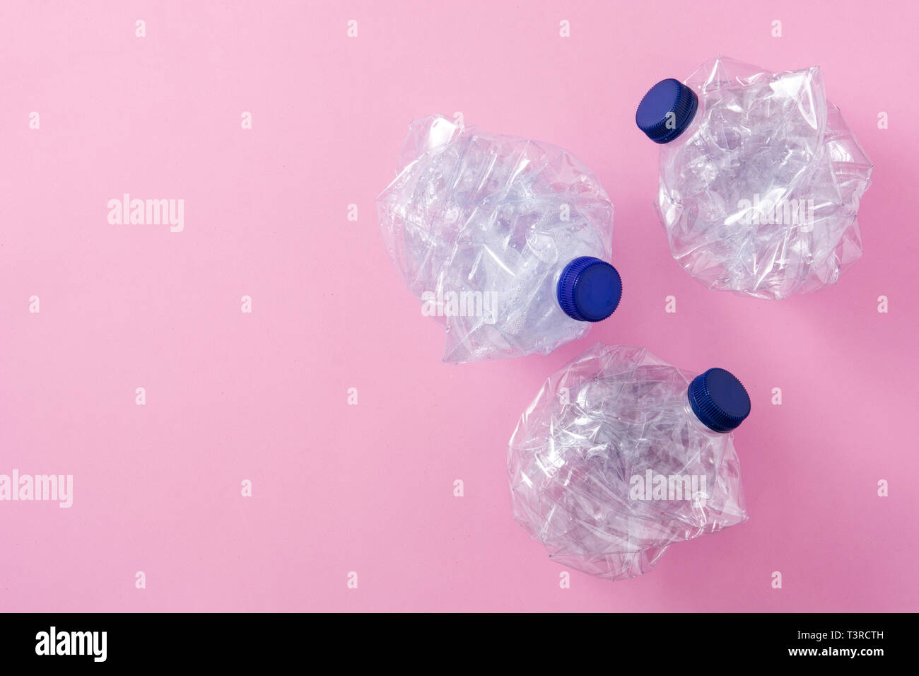 Disposable waste plastic bottles on pink background. Top view. Copyspace Stock Photo