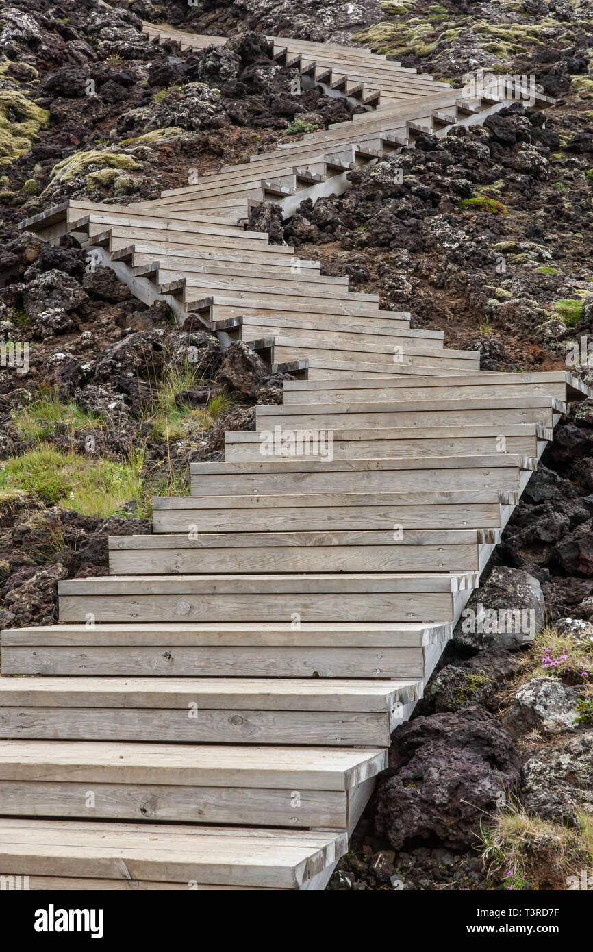 Zigzag wooden staircase amongst volcanic rocks. Iceland. Stock Photo