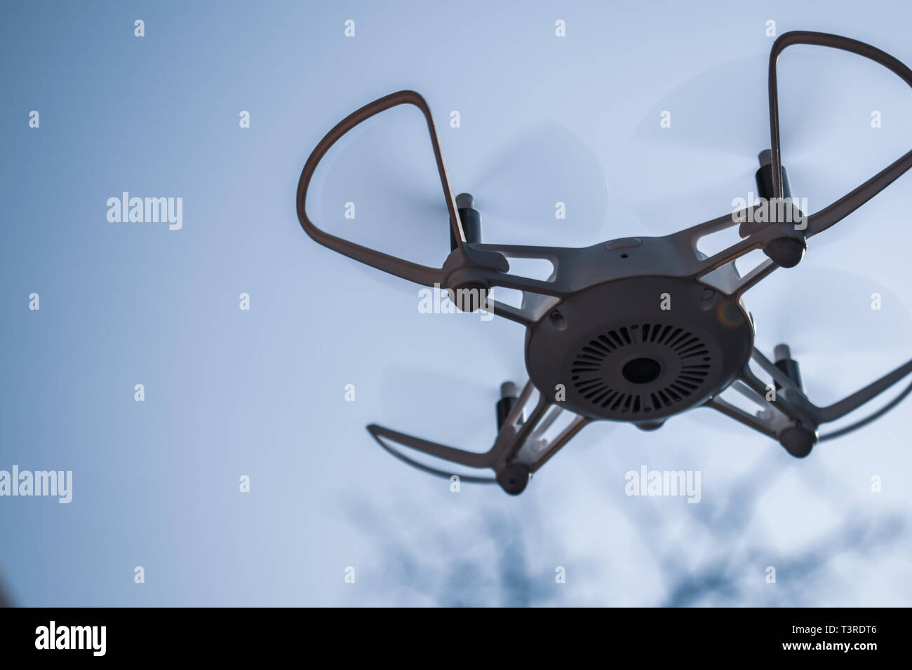 Quadcopter drone hovering in a blue sky Stock Photo