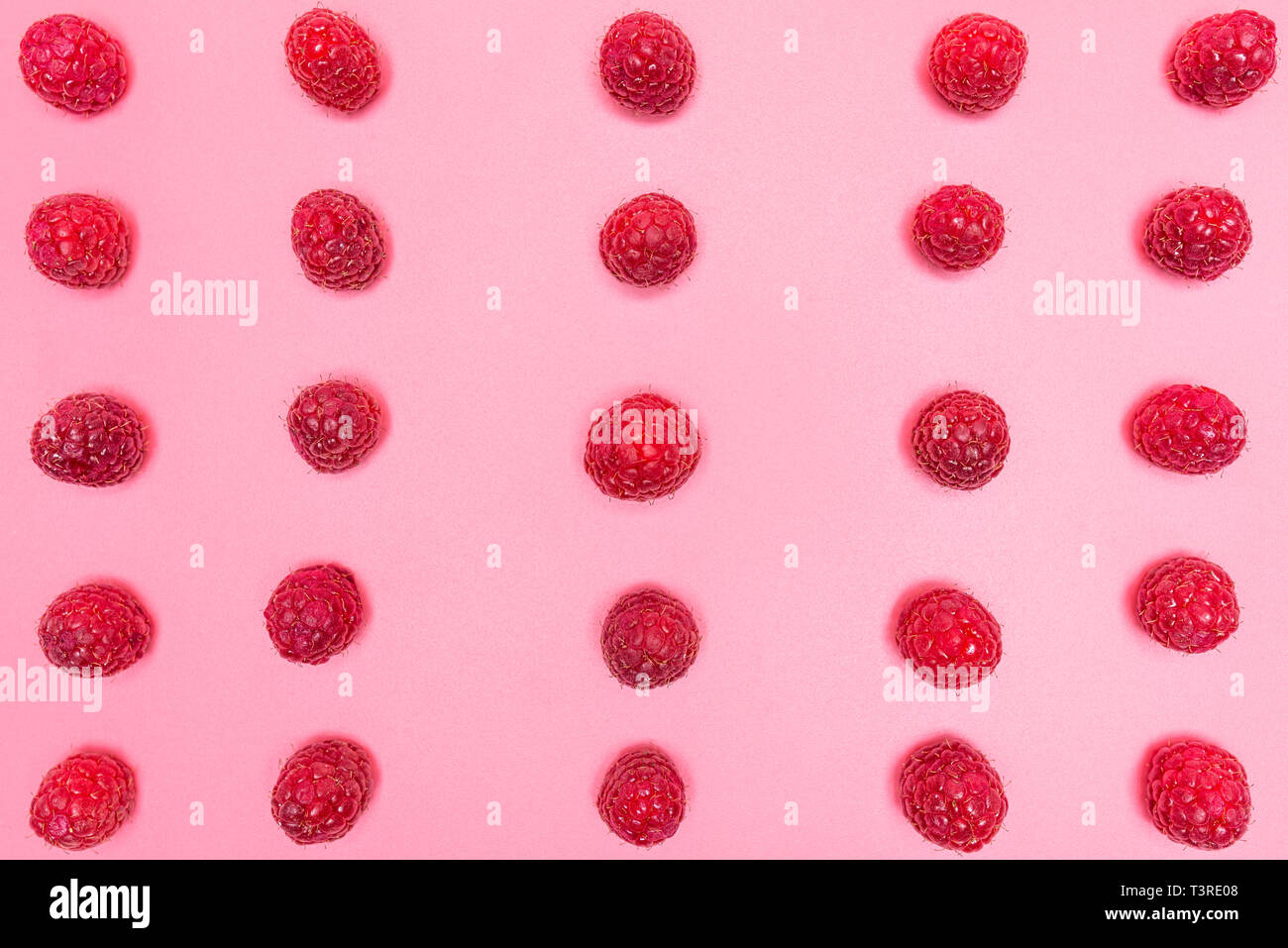 Pattern made from fresh raspberries, top view, flat lay pattern, isolated on a light pink background. Stock Photo