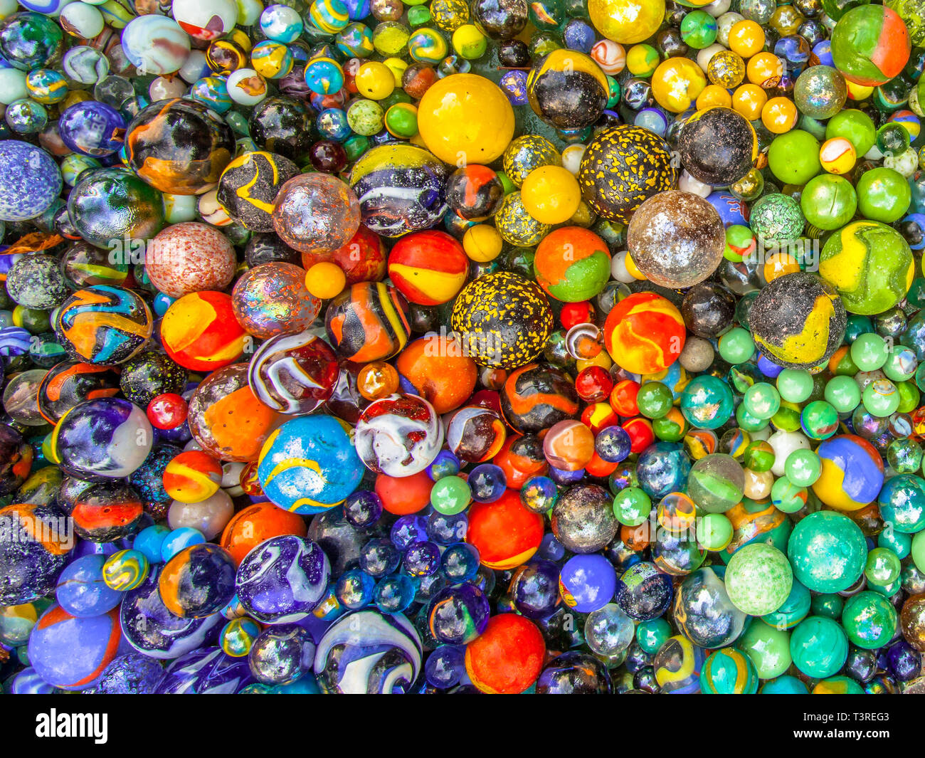 Glass marbles of different sizes in a color pattern as methaphor for multicultural community coexistence Stock Photo