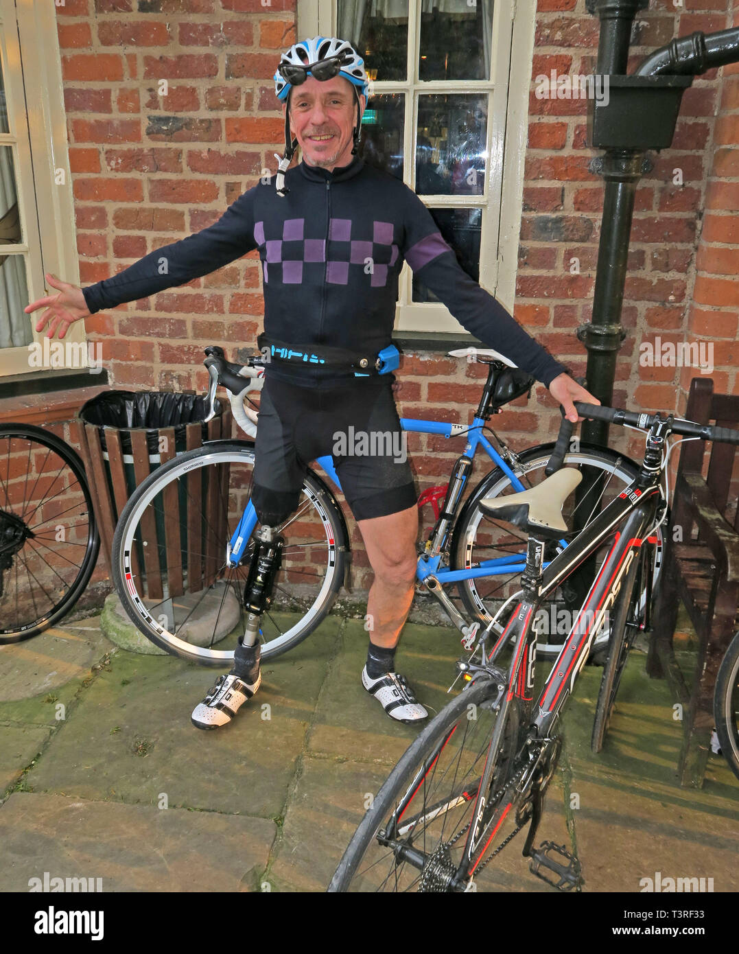 Keith, cyclist cycling with a prosthetic leg, in Lycra cycling clothing, at the Vine Inn, Barns Lane, Dunham Town, Cheshire, England, UK, WA14 5RU Stock Photo