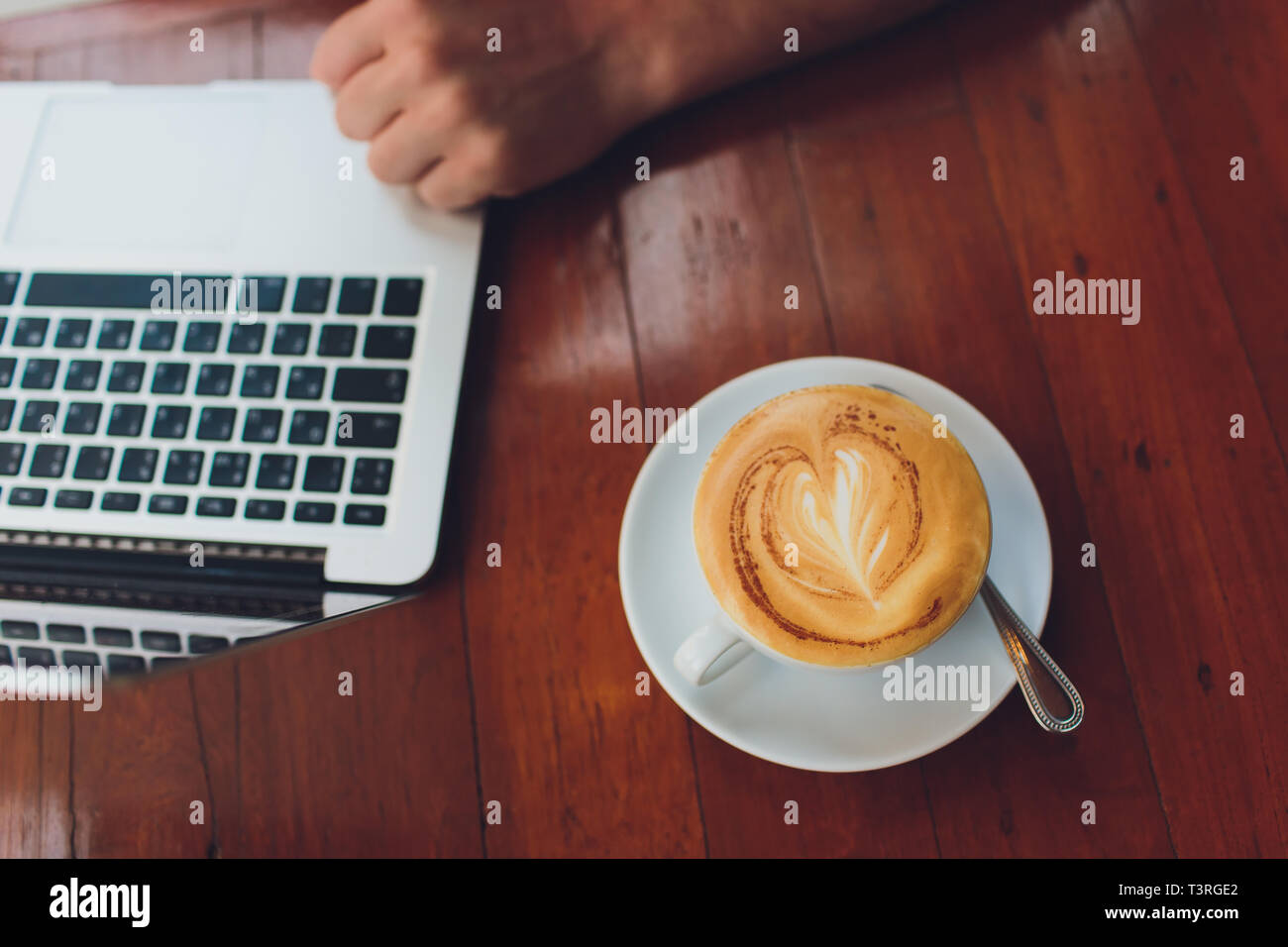 Close up of a man hands typing in a laptop in a coffee shop terrace in ...