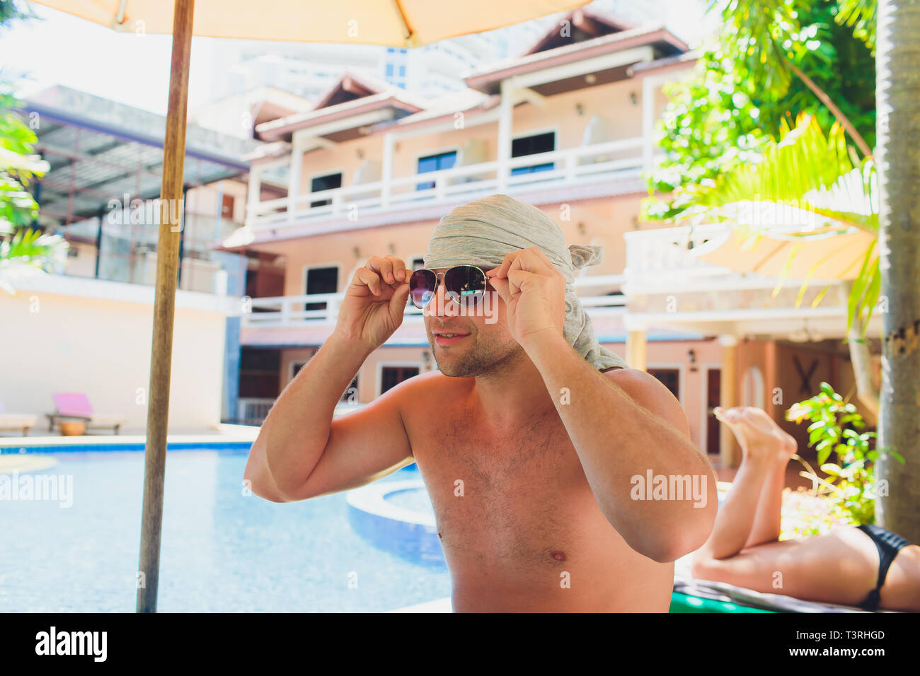 Handsome joyful man lying on the sun bed. Stock Photo