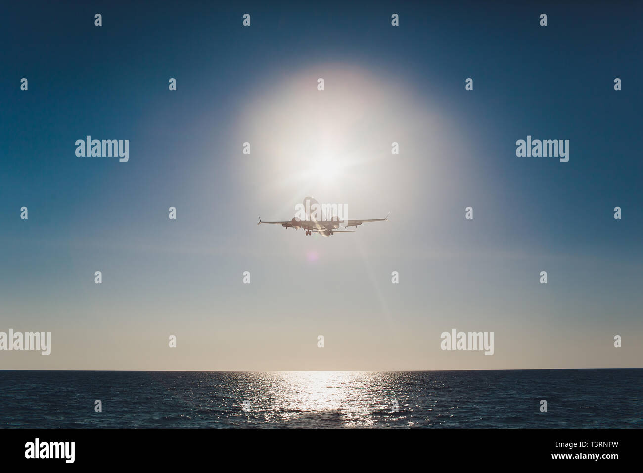 Airplane flying under blue sky and white cloud in Phuket, Thailand. Stock Photo