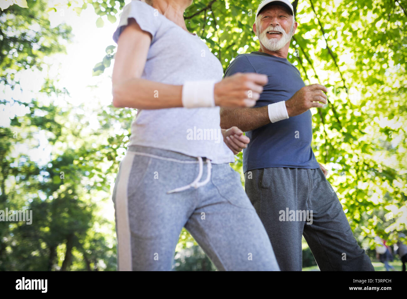 Fitness, sport, people, exercising and lifestyle concept - senior couple running Stock Photo