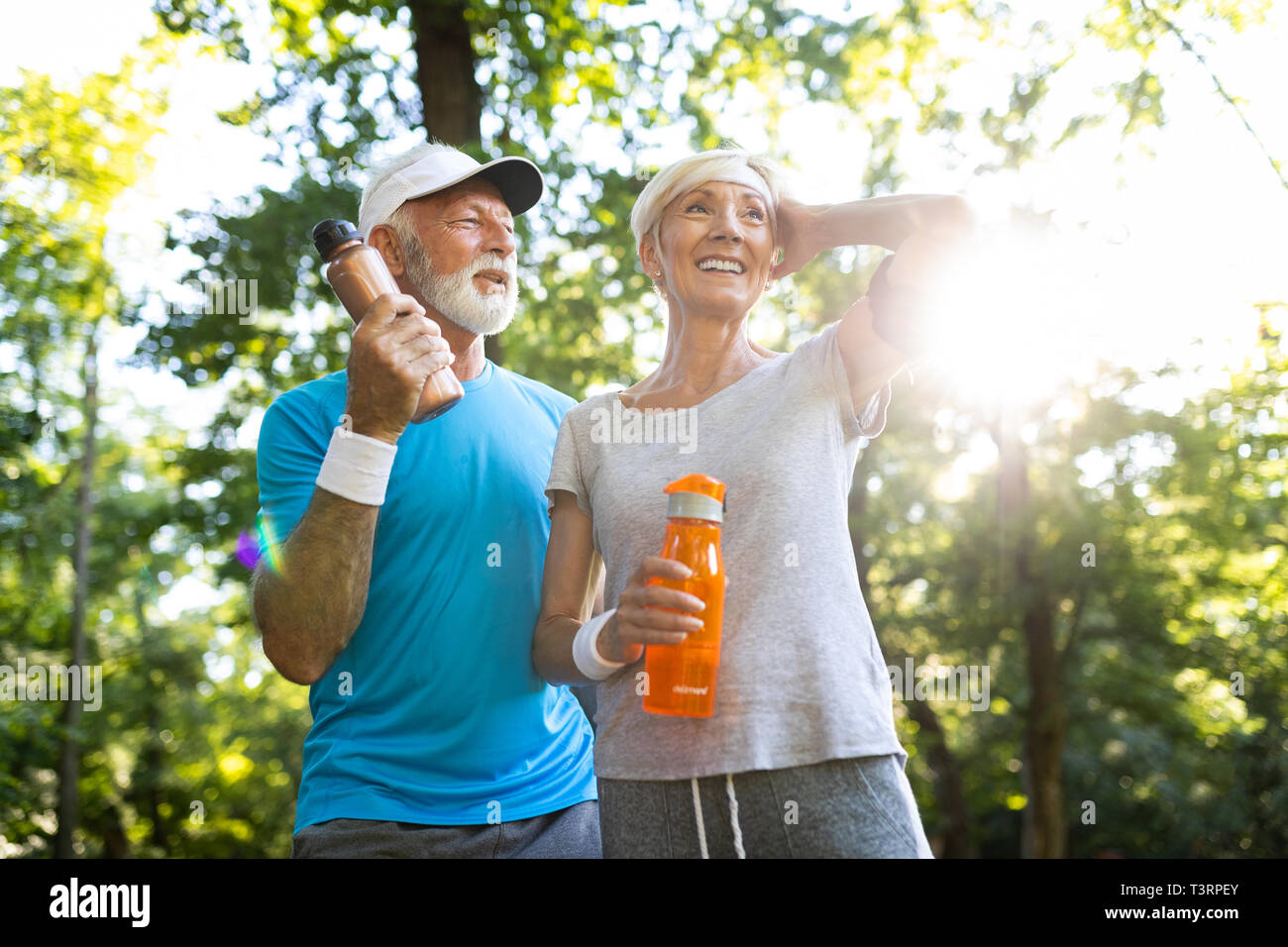 Fitness, sport, people, exercising and lifestyle concept - senior couple running Stock Photo