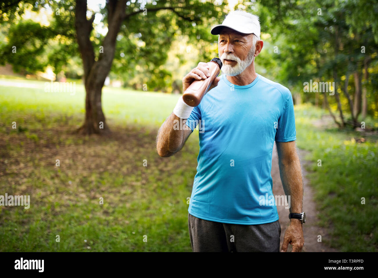 Portrait of athletic mature man after run. Handsome senior man resting after jog at the park Stock Photo