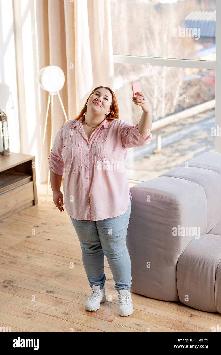 Top view of a joyful plump woman taking photos Stock Photo