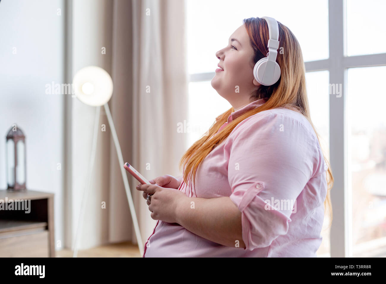 Delighted nice woman enjoying her favourite music Stock Photo