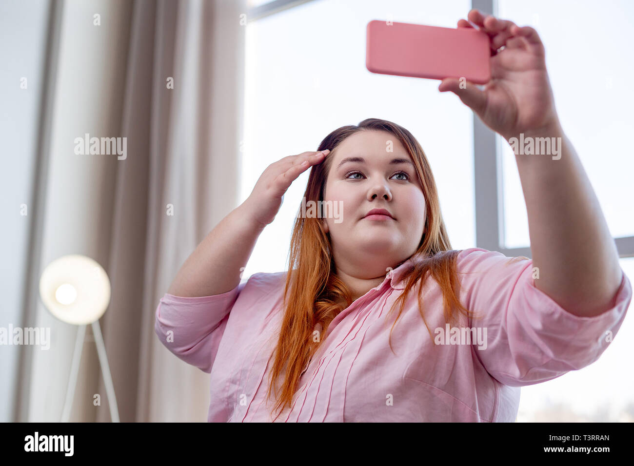 Pleasant overweight woman wanting to look pretty Stock Photo