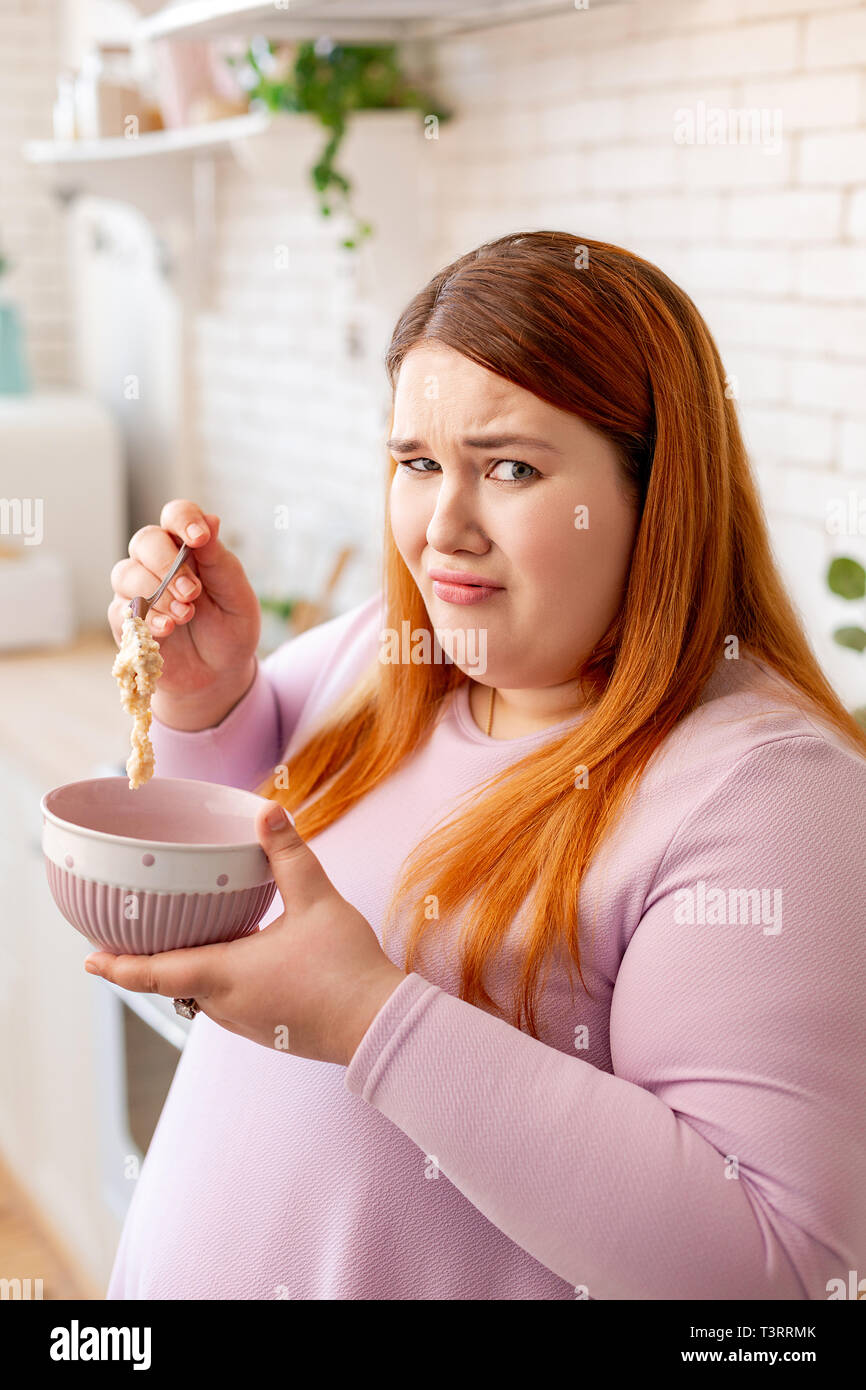 Unhappy plump woman not liking her food Stock Photo