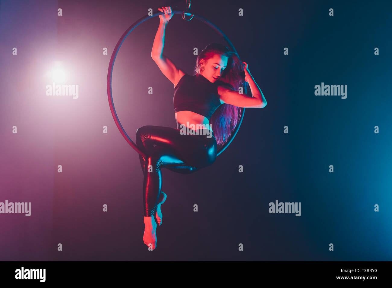 Aerial acrobat in the ring. A young girl performs the acrobatic ...