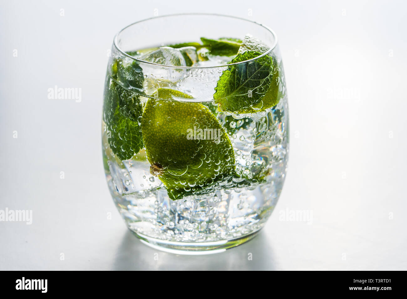 Summer cocktail concept: fresh mojito on chopping board with green limes Stock Photo