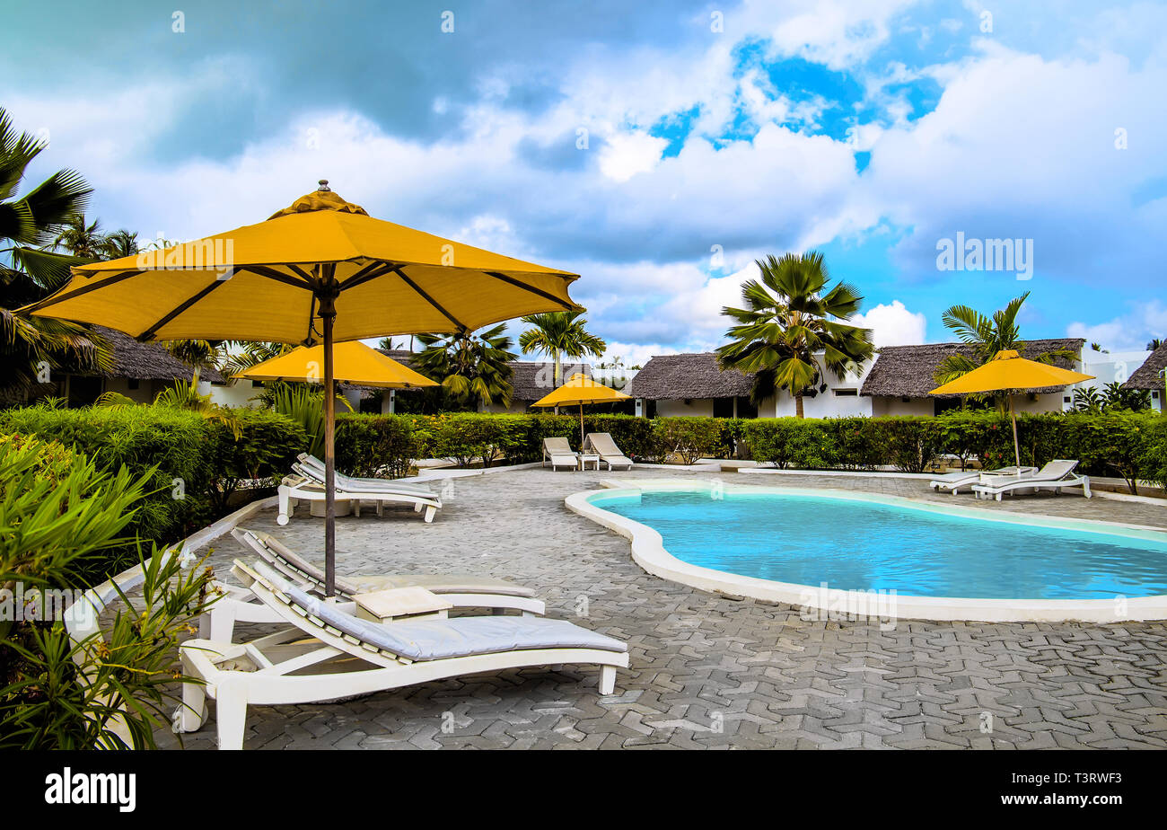 swimming pool and chair with umbrellas around in hotel at the open air. Stock Photo