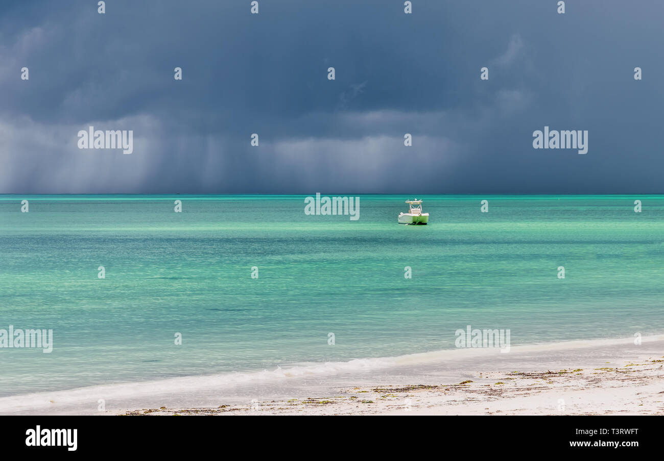 one white boat in the  Indian ocean near by coast before the storm without people on. Stock Photo