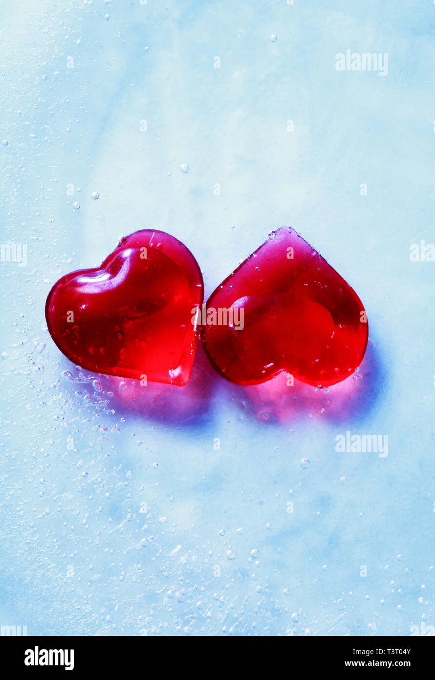 Valentines Day greeting card. Two red hearts in blue frozen water with free space Stock Photo