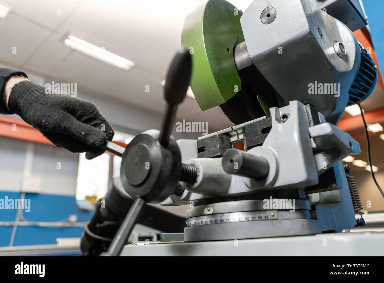 worker cuts a piece of material with a circular saw machine. Industrial