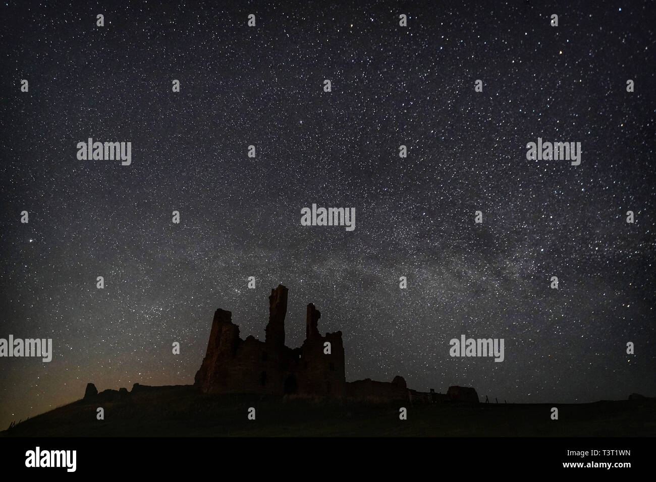 The Milky Way and millions of stars over Dunstanburgh Castle in the early hours of Thursday morning. Stock Photo
