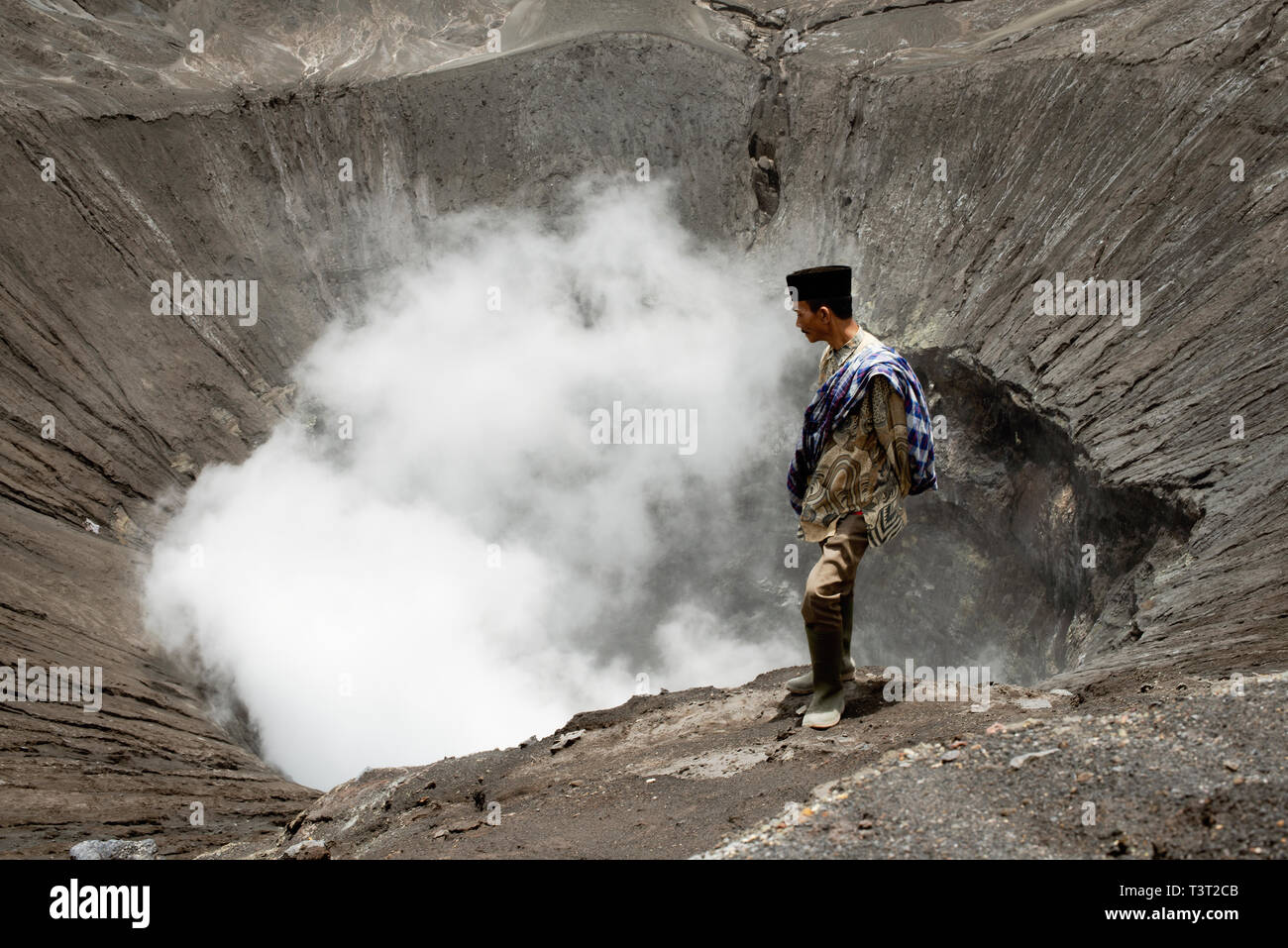 Tenggerese Man Standing On The Edge Of An Active Volcano In Bromo Tengger Semeru National Park. January 17, 2014 - Java, Indonesia Stock Photo