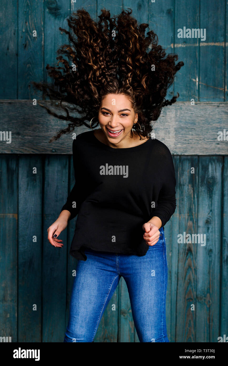 Mixed race woman tossing her hair Stock Photo