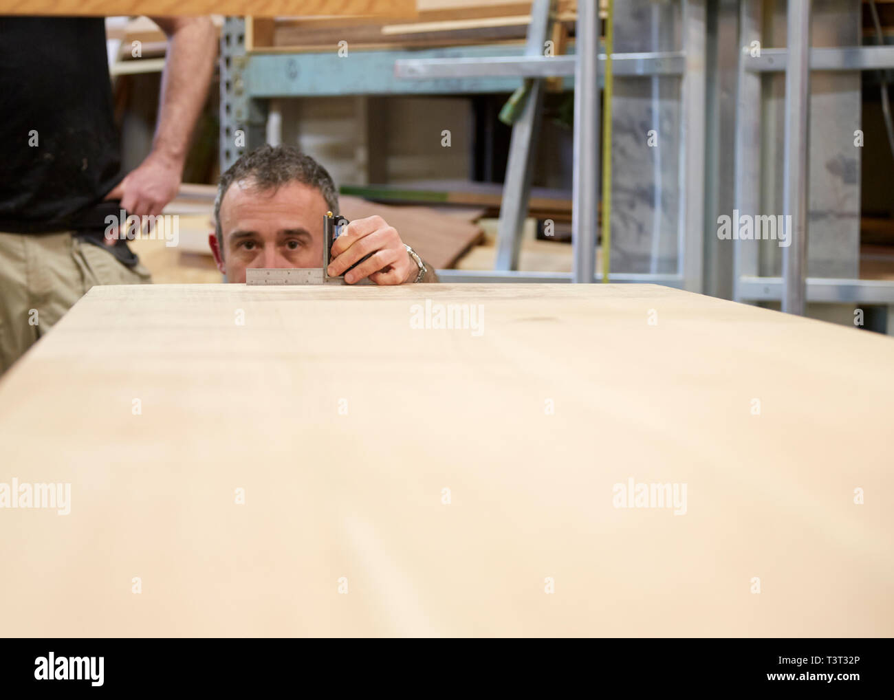 Carpenter measuring wood in workshop Stock Photo