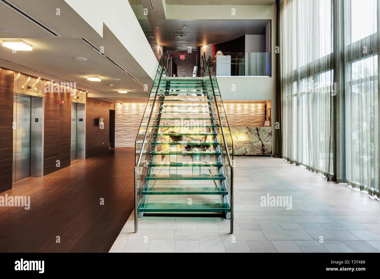 Glass staircase in hotel lobby Stock Photo - Alamy